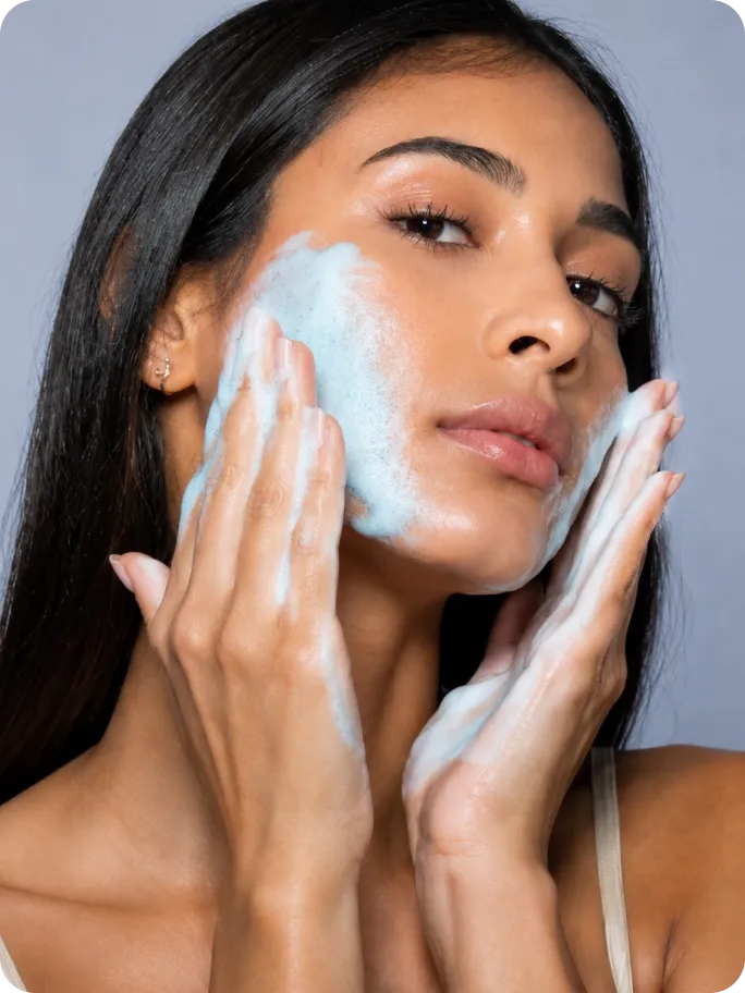 Mulher massageando a espuma azul no rosto