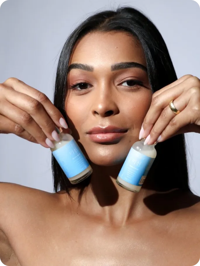 Mulher segurando dois frascos do Sérum Facial Yoomi